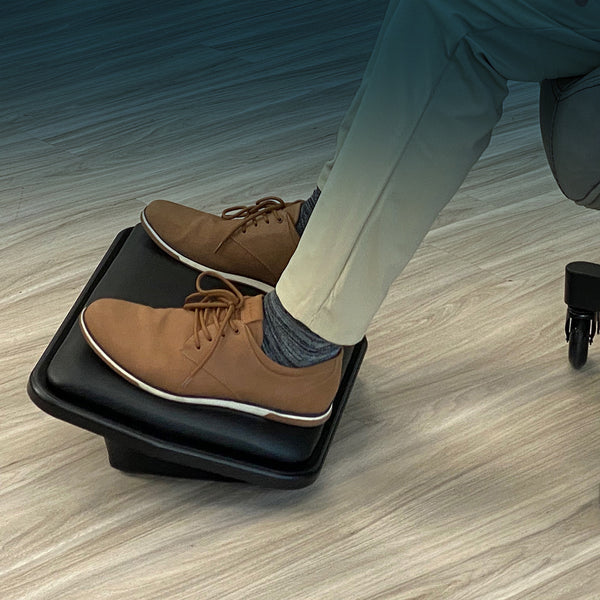 This is an image of a Lifeform© Chairs Footstool under a desk with a persons feet on it